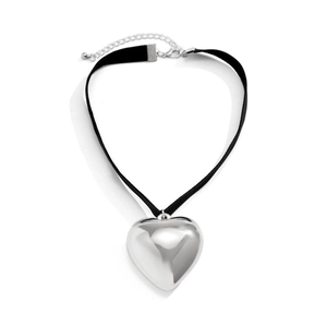 Detail of large silver heart pendant on a black fabric choker with lobster clasp