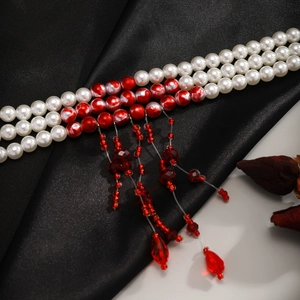 Close-up of gothic triple-strand pearl necklace with blood-red drop fringe tassels