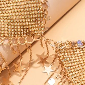 Macro view of gold mesh body chain with colorful rhinestones and star charms
