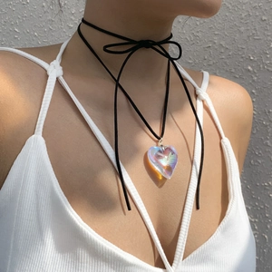 Detail of a large holographic heart pendant on a multi-layered black cord choker necklace