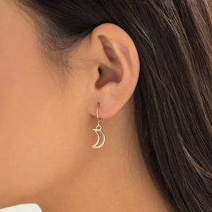 Detailed view of model wearing gold crescent moon earrings with French vintage style