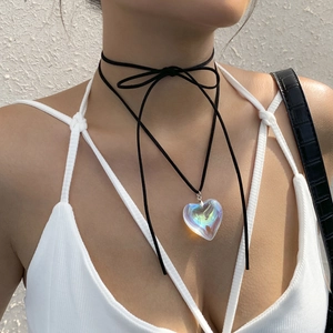Close-up of black cord choker with colorful crystal heart pendant on female model