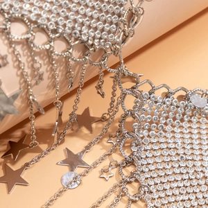 Detail of silver mesh body chain featuring sparkling rhinestones and star tassels