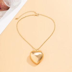 Detail of a high-polished golden heart pendant on an adjustable O-chain necklace