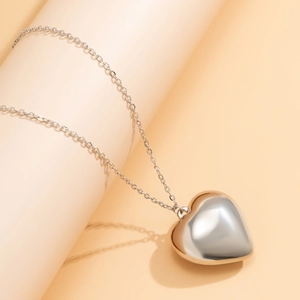 Macro shot of polished silver 3D heart pendant necklace with shiny metallic reflection