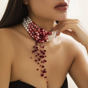 Detail of gothic choker featuring multilayered pearls and red crystal bead tassels
