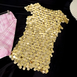 Dettaglio dei lustrini dorati lucidi di un abito sexy a catena per feste e club