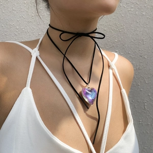 Detail of adjustable black ribbon bow choker featuring a gradient heart-shaped pendant