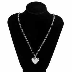 Polished silver heart pendant hanging on a classic velvet link chain displayed on a neck bust