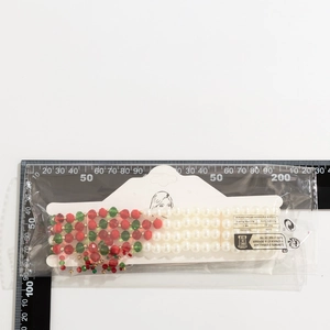 Close-up of gothic blood drip tassel choker beads with measurement scale on white background
