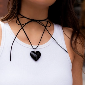 Close-up of a large black heart pendant on a multi-layered adjustable wax cord choker