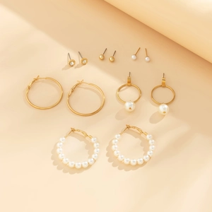 Detailed set of 6 pairs of gold earrings with pearls and crystals on a beige background
