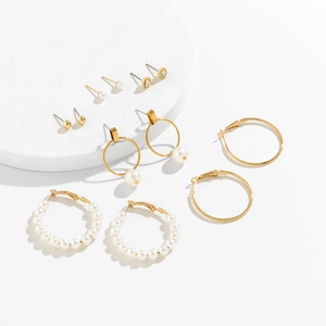 Detailed set of six pairs of gold-plated earrings with pearls and stars on a white base