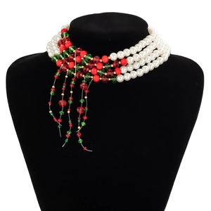 Close-up of a multi-layer faux pearl choker with festive red and green beaded tassels