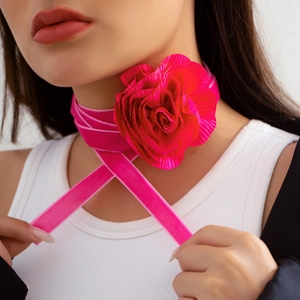 Detail van een grote 3D-fluwelen rozenchoker in felroze met elegante lange strikbanden