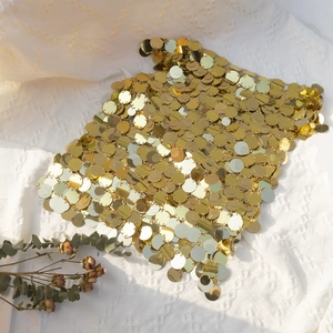 Dettaglio della catena per il corpo con paillettes dorate e dischi metallici geometrici