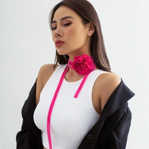 Detail van een roze rozen choker met lange fluwelen linten en een blazer
