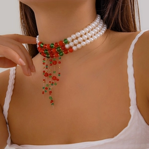Close-up of triple-layer pearl choker with red and green bead tassels for Christmas