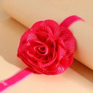 Detail van grote magenta stoffen rozenchoker met fluwelen lint en zachte bloemblaadjes