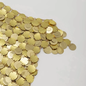 Dettaglio catena corpo con paillettes dorate che mostra dischi di metallo lucido collegati