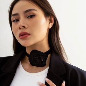 Gedetailleerd overzicht van een zwarte fluwelen rozen choker op model met blazer