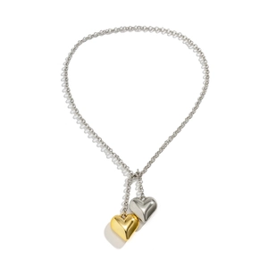 Macro shot of 3D heart pendants in gold and silver finish on a chic linked chain