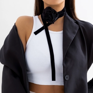 Detail van een zwarte fluwelen rozenchoker met lange linten bij een fotomodel