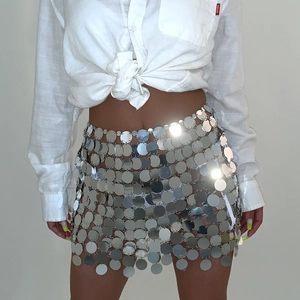 Dettaglio ravvicinato di minigonna con paillettes argento e design metallico traforato