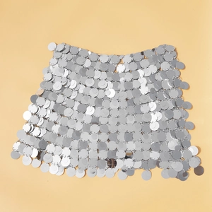 Dettaglio di paillettes argento e anelli metallici su una gonna a catena corpo da disco