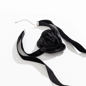 Detail van een zwarte fluwelen choker met een realistische 3D-stofroos en metalen sluiting