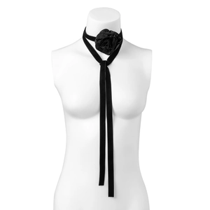 Gedetailleerde macro-opname van zwarte fluwelen choker met roos en lange linten