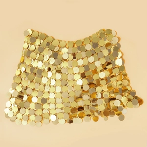 Vista dettagliata delle paillettes in metallo dorato e delle maglie della catena del corpo