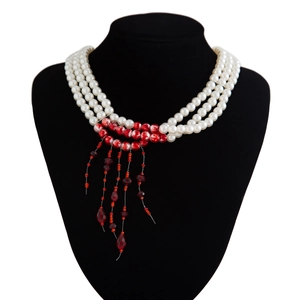 Detail of gothic multi-layer pearl choker with red crystal pendant and fringe tassel