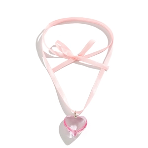 Detail of pink crystal heart pendant on satin ribbon necklace with bow decoration