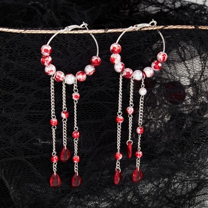 Detail of Gothic blood-stained pearl hoop earrings with crystal dripping tassels on lace