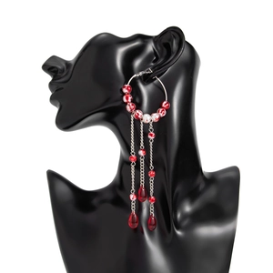 Detailed view of Gothic blood-dripping pearl tassel earrings on a display model