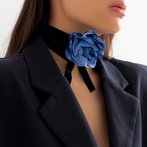 Detail van een blauwe stoffen roos choker met een zwarte fluwelen vetersluiting