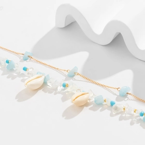 Detailansicht der Strandkörperkette mit Muscheln, blauen Perlen und Goldgliedern