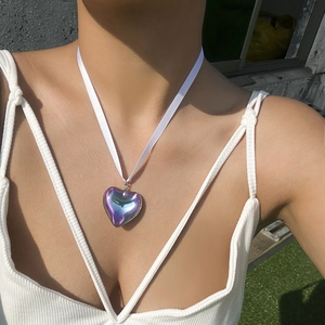 Detail of a large gradient heart pendant with iridescent blue and purple metallic finish