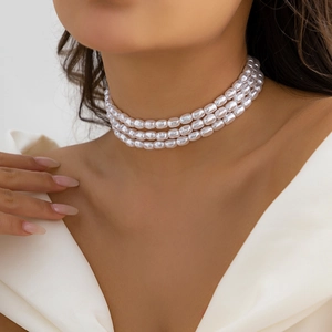 Détail d'un collier ras du cou à trois couches de perles avec finition élégante
