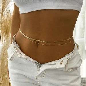 Detail of a layered golden metal waist chain with flat snake bone and fine tassel chains