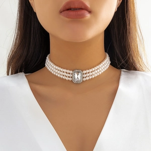 Gros plan d'un choker à trois rangs de perles avec pendentif en cristal vintage