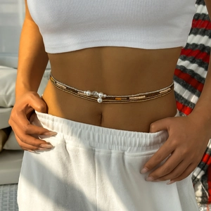 Close-up of layered waist beads with faux pearls and tiny beads on model's waist