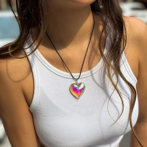 Detailed view of iridescent heart pendant on a minimalist black cord necklace