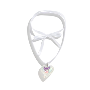 Macro detail of iridescent heart pendant on adjustable white ribbon choker necklace