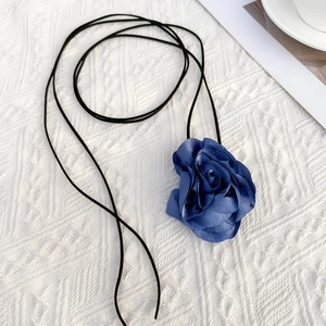 Detailopname van een handgemaakte donkerblauwe stoffen roos choker met zwart koord