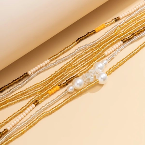 Detail of bohemian beach body chain with multicolored glass beads and faux pearls