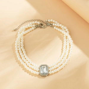 Détail du collier de perles à trois rangs avec pierre rectangulaire et cristaux brillants