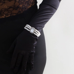 Gros plan d'un bracelet de perles à trois rangs avec un grand pendentif en cristal