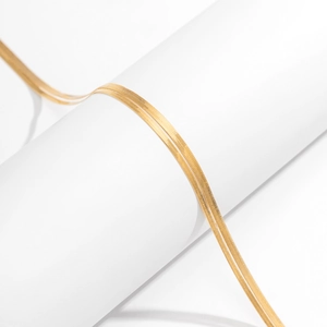 Detailed view of glossy gold double-layered herringbone body chain on white prop